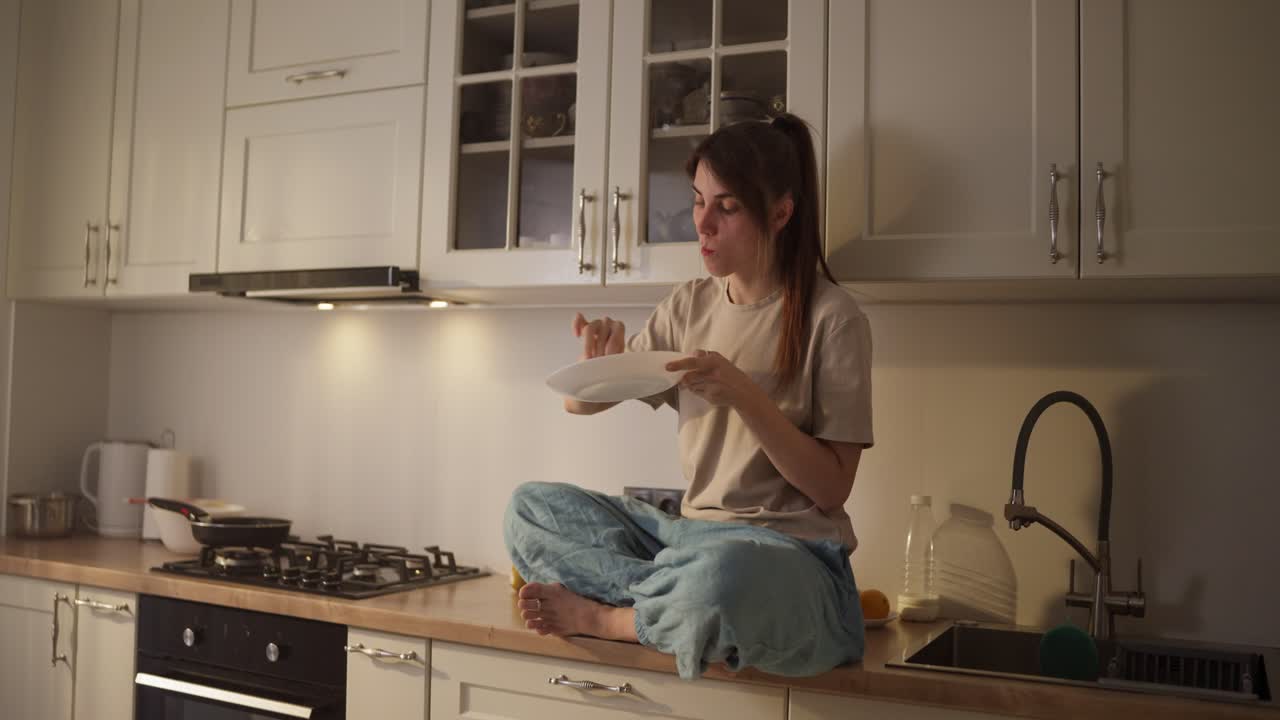 Donna che mangia uno spuntino in cucina