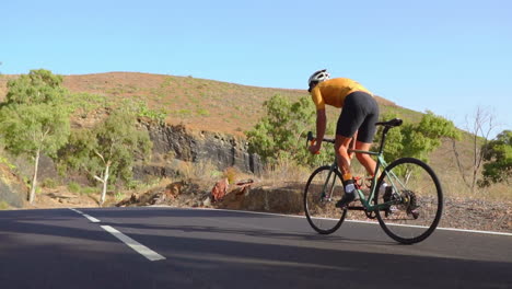 embracing the tranquility of the morning, a man cycles on a road bike along an unoccupied road. the slow-motion video amplifies the concept of extreme sports