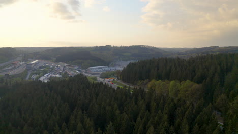 Vista-Aérea-Descendiendo-Por-Encima-Del-Bosque-Hasta-El-Circuito-De-Spa-francochamps-Racetrack-Stavelot-Bélgica