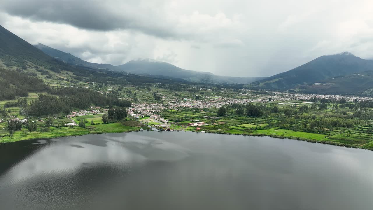 Aerial footage of hazy mountain range covered in white clouds and mist on an overcast day.