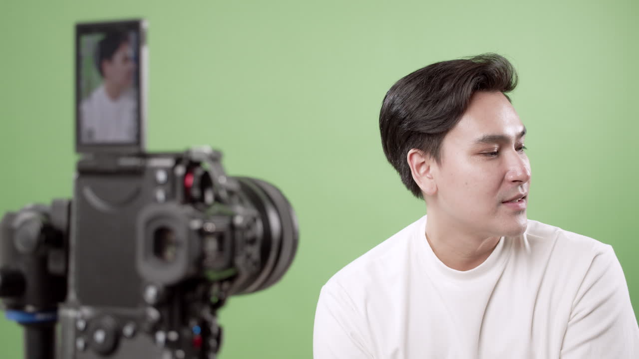 A young creator shares insights while filming a green screen showcasing video production techniques.