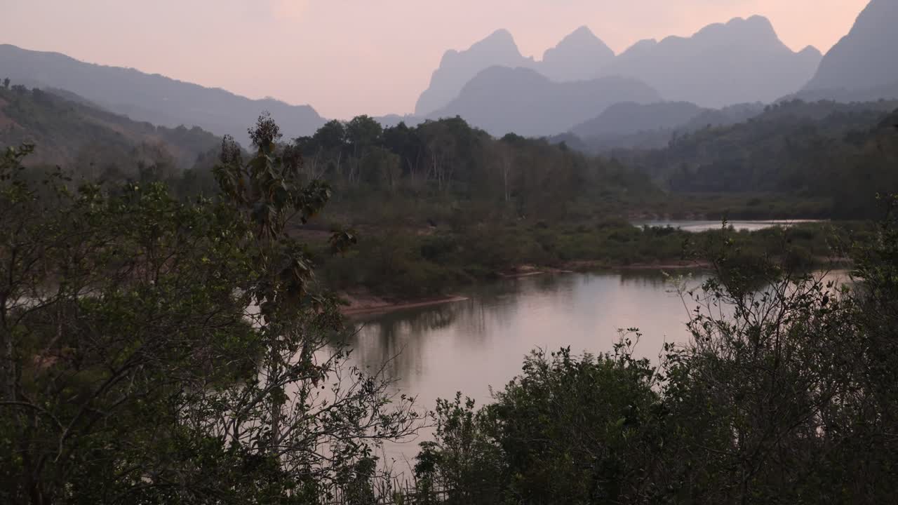 Tramonto rosa dietro cime frastagliate nella città di montagna di Nong Khiaw in Laos, Sud-est asiatico.