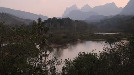 pink sunset behind jagged peaks in the mountain town of nong khiaw in laos, southeast asia