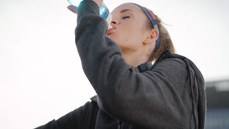 Tilt-up-video-shows-of-sporty-woman-drinking-water