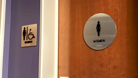 women's bathroom sign on wooden door in corporate office environment