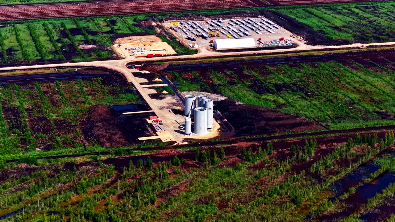 Drone view of silos and industrial facilities for concrete production at a new wind farm development project. Aerial forward perspective