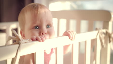 Bebé-Parado-En-La-Cama-En-Casa.-Retrato-De-Una-Niña-Parada-En-La-Cuna.-Ojos-De-Bebe