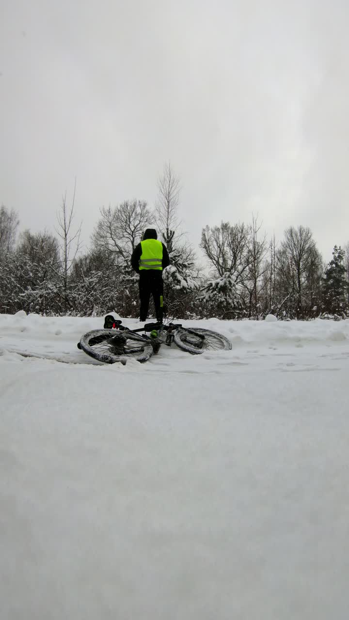 Static vertical Riga shot of cyclist stopping in snow showing basic human needs