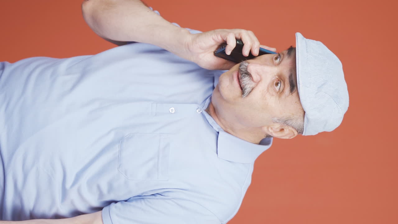 video vertical de un anciano recibiendo el evangelio por teléfono.