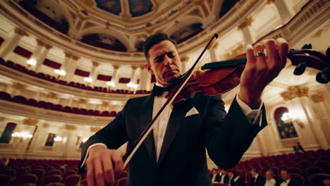 violinist performing in a grand opera house