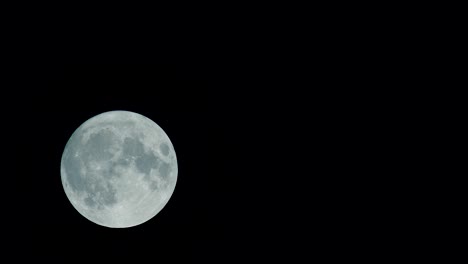 full moon in the dark night sky. the moon is traveling from left to right.