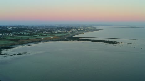 aerial drone footage of salthill coast during the magic hour on a sunny, frosty day. galway, ireland.