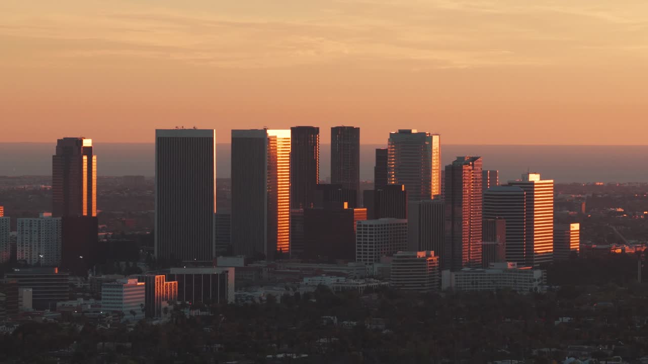 Toma aérea panorámica con teleobjetivo de Century City durante la hora dorada en Los Ángeles, California. 4K
