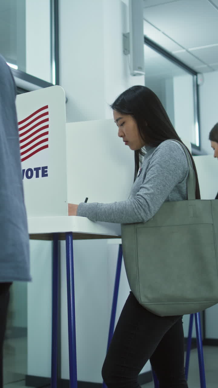 votantes multiculturales, la gente de estados unidos vota en las cabinas de votación en la estación de votación. hombre indio pone la boleta en la caja. día nacional de elecciones en los estados unidos de américa. deber cívico y concepto de patriotismo.