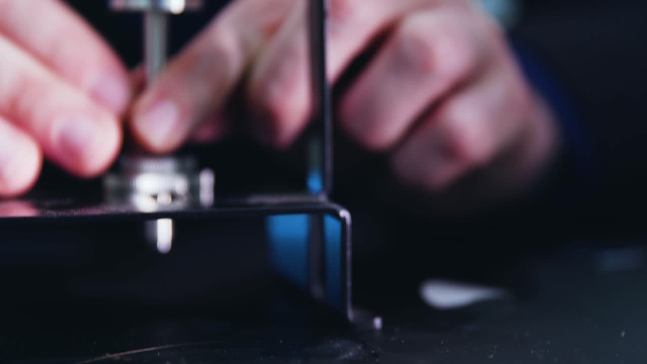 Close Up of hands screw pieces of microscope