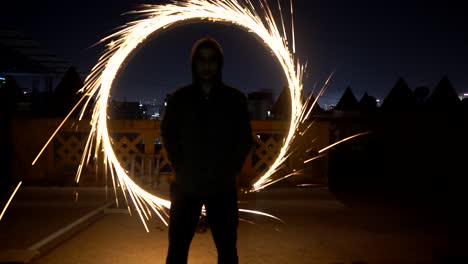 fire ring behind man light painting with fire works