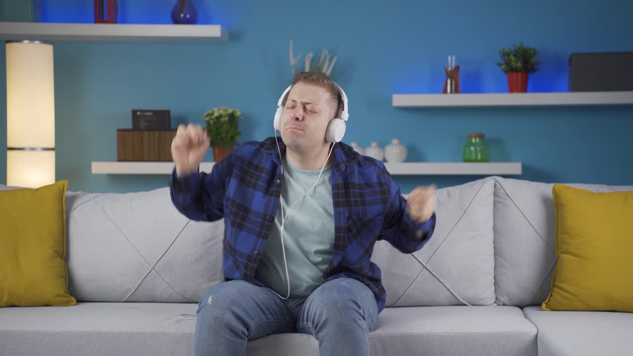Happy man listening to music with headphones.