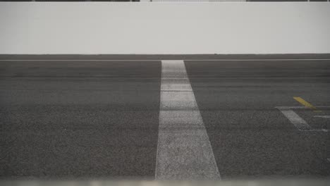 cars of different colors passing by the finish line on a racetrack in 4k