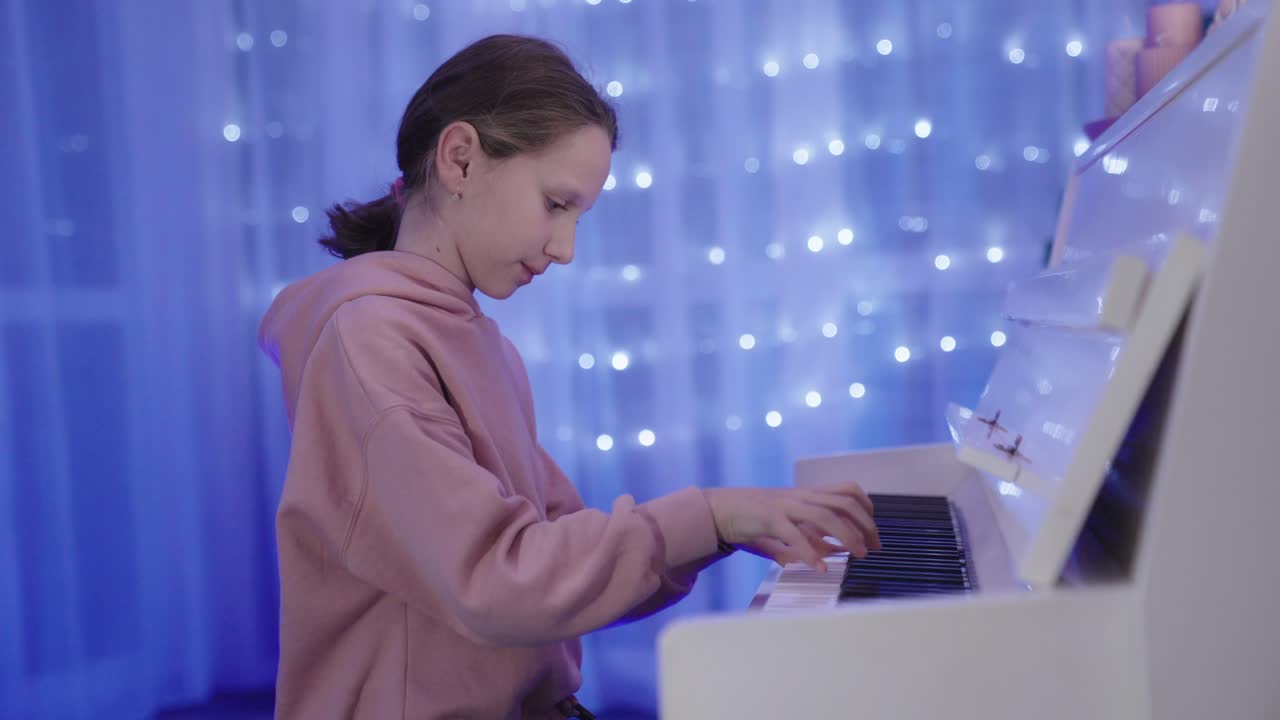 una niña bonita y talentosa toca el piano blanco con temperamento