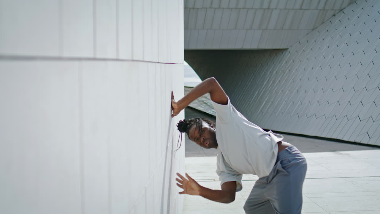 Artistic guy dancing contemp urban place. Brown skin dancer street choreography