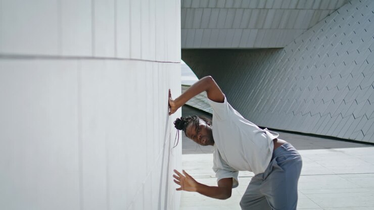 Artistic guy dancing contemp urban place. Brown skin dancer street choreography
