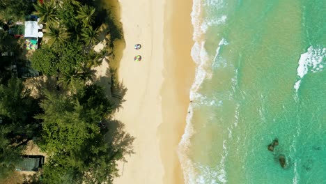 4K-Cinematic-nature-aerial-footage-of-a-drone-flying-over-the-beautiful-beach-of-Surin-in-Phuket,-Thailand-on-a-sunny-day