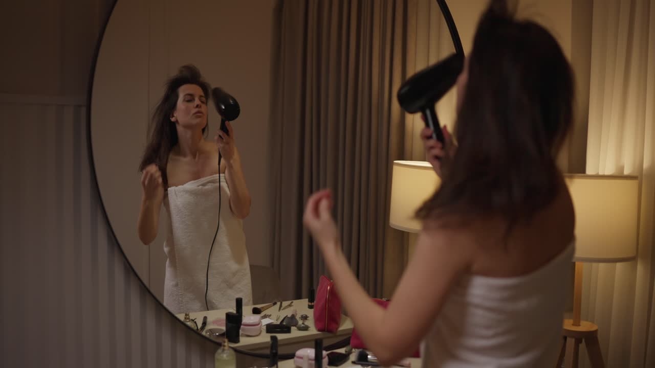 Woman drying hair in mirror