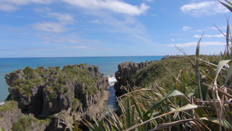 reveal shot of the famous pancake rocks, waves hit the cliffs in the background, punakaiki, new zealand