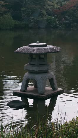 stone lantern in a japanese garden pond