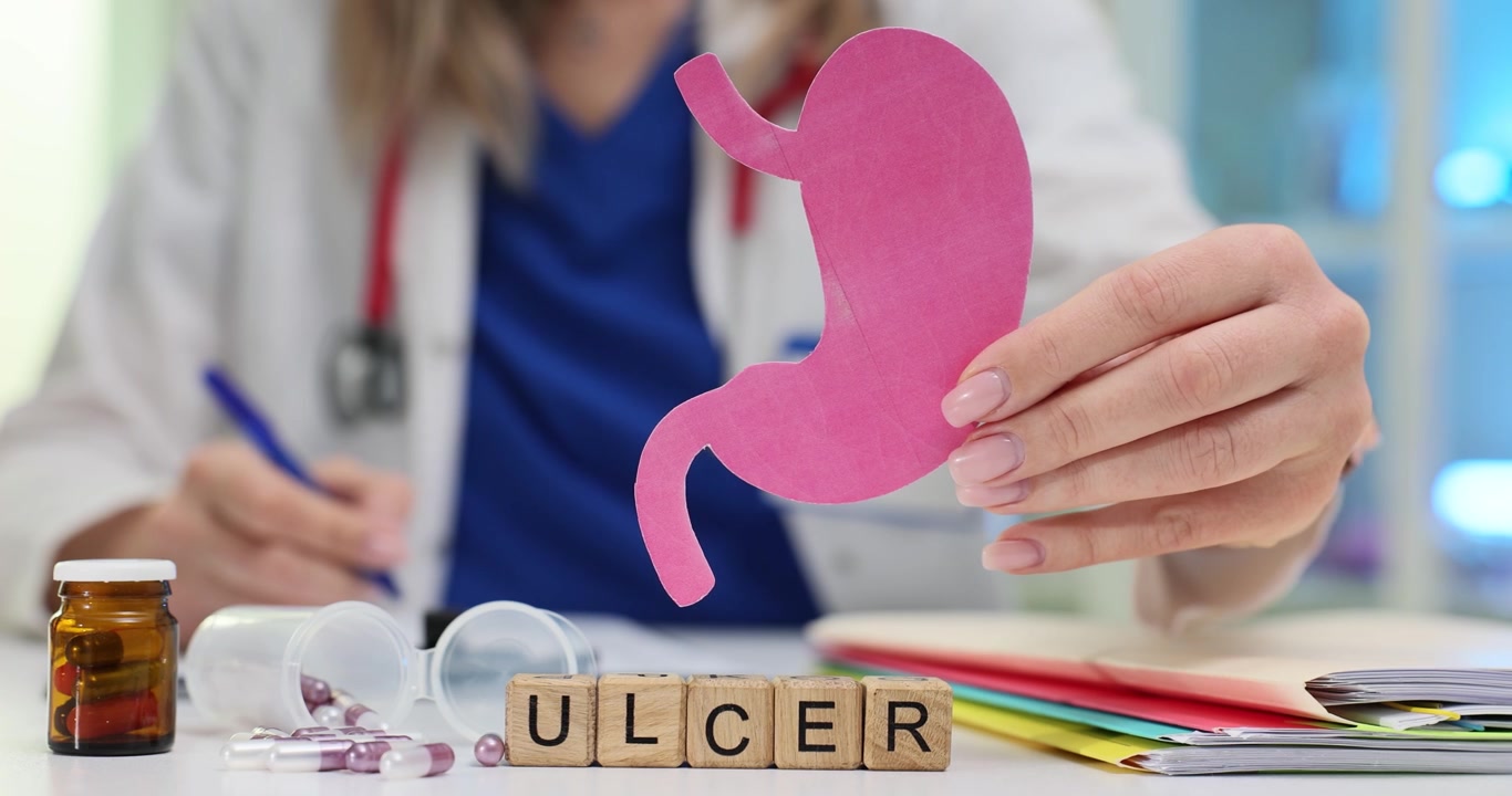 Word ulcer on cubes and doctor showing paper stomach