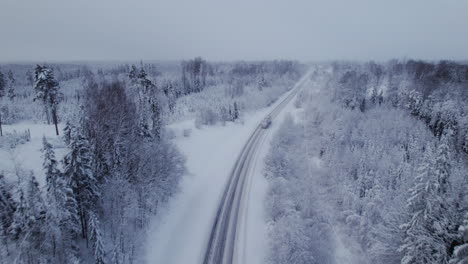 4K-areal-scenic-view,-drone-flying-over-highway-covered-with-snow-and-ice-during-snowfall