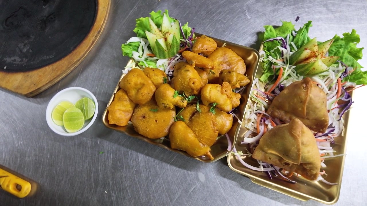 Piatto di spuntini fritti indiani con samosa e pakora