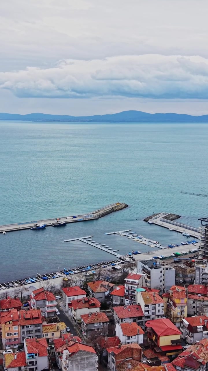 Deniz kenarındaki limanı ve binalarıyla sahil kasabasının kuşbakışı görünümü
