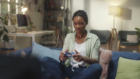 young woman playing video games on couch