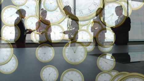 animación de relojes analógicos dorados cayendo, compartiendo ideas y de pie contra una ventana de vidrio en la oficina