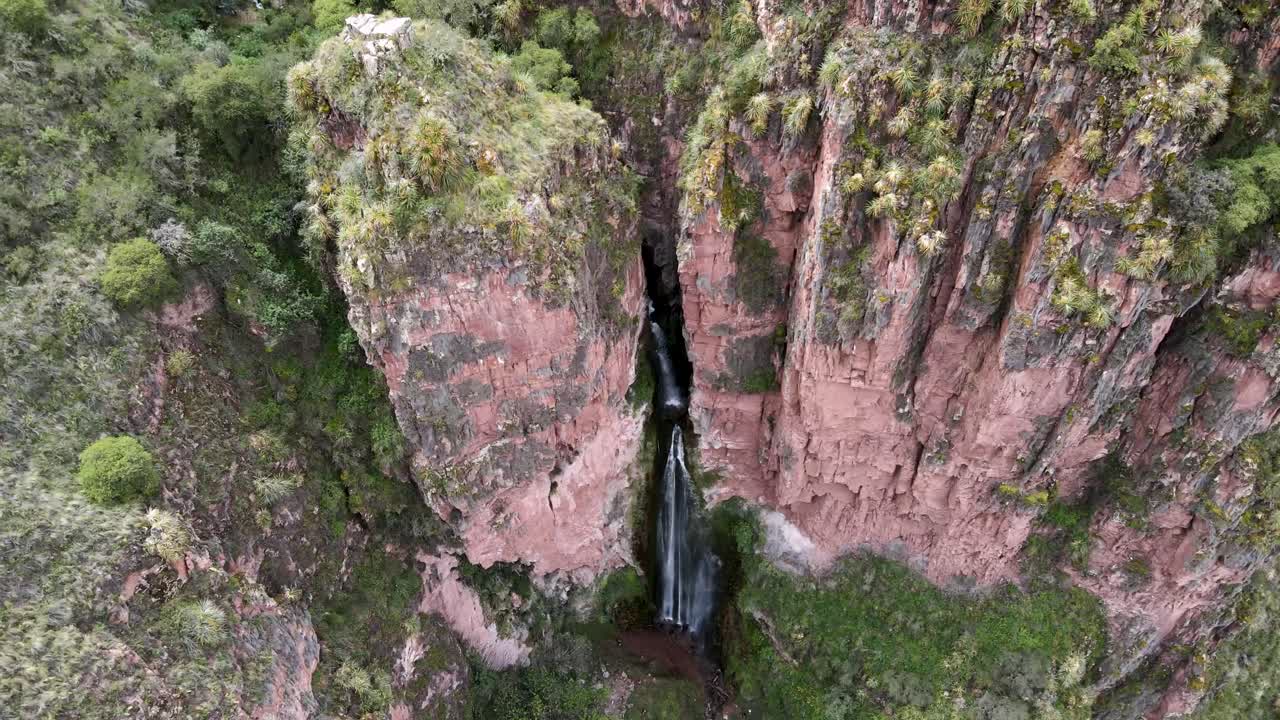 Crane shot Of Perolniyoc Waterfall Flowing Out From Rocky Mountain, Sacred Valley in Cusco, Perú