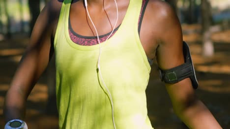 female jogger stretching in the forest 4k