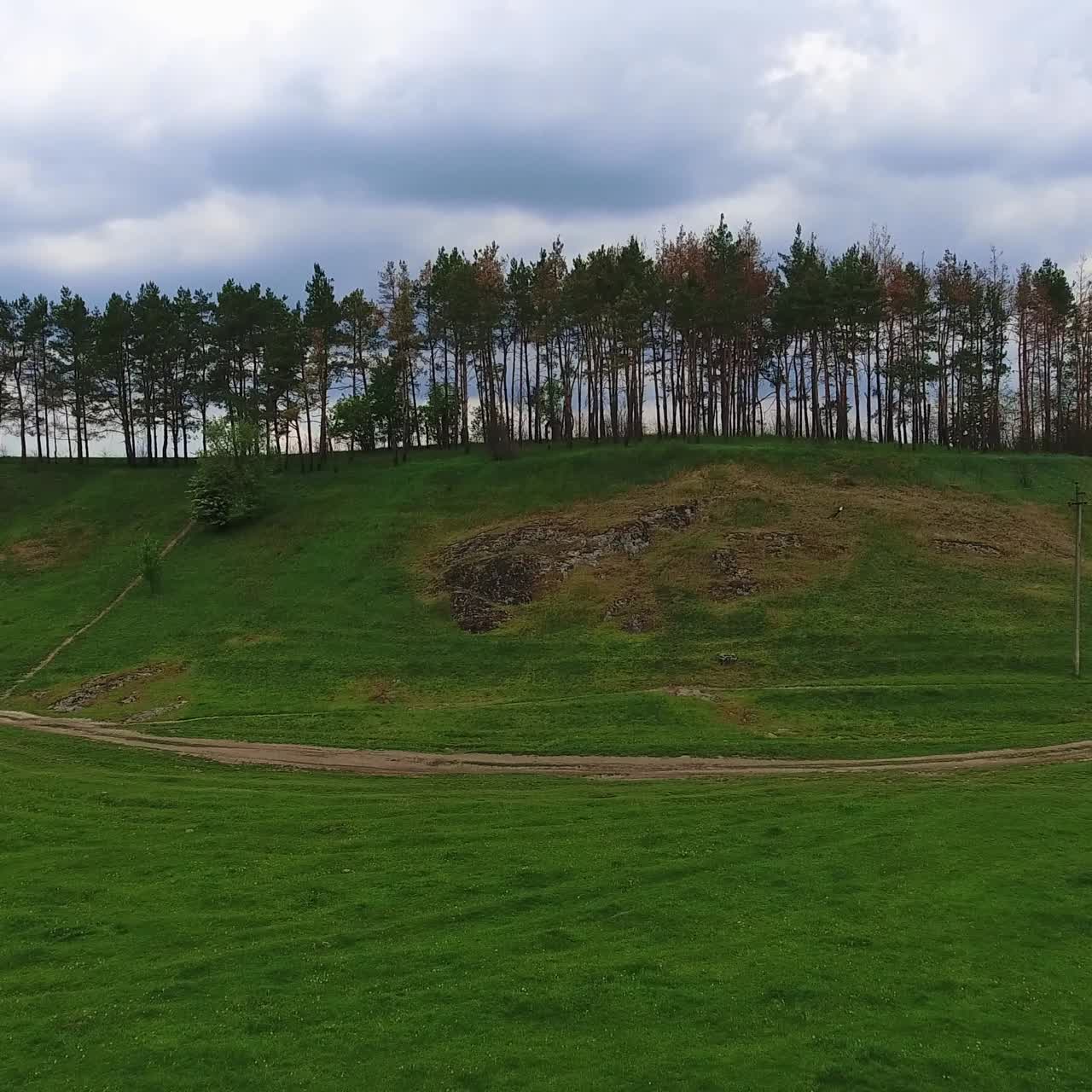 Cloudy summer day in the nature. Couple holding horses stands at the river bank. Top view