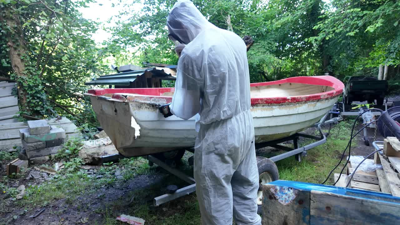 Removing Old Fiberglass from Lake Boat Hull during Restoration