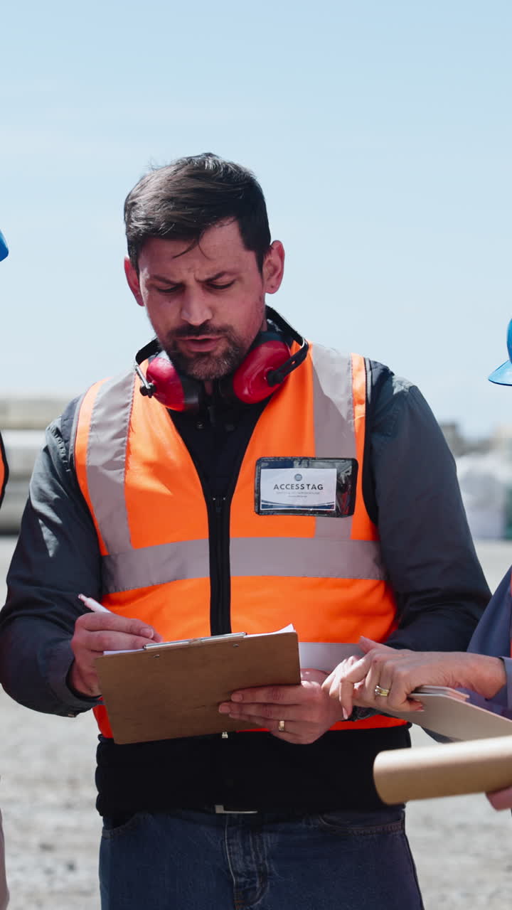 Man in Safety Vest Discussing Plans on a Construction Site