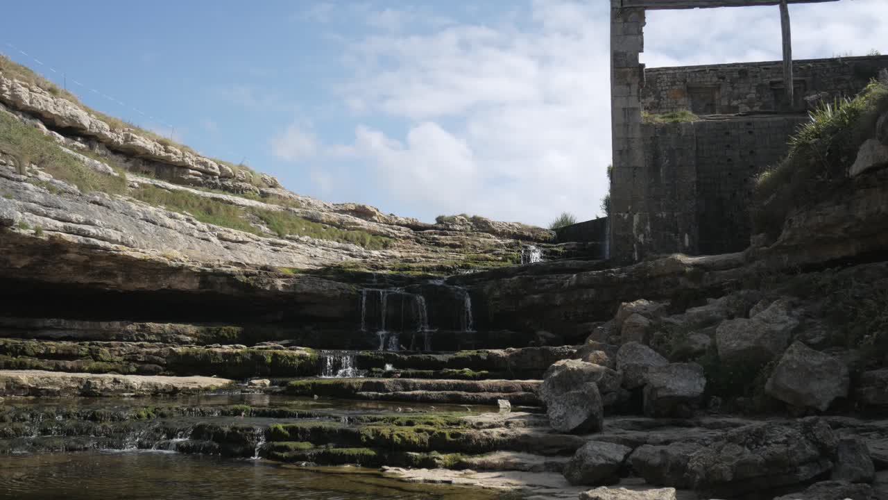 Rock formations and water streams flowing near the Bolao Windmill in Cantabria, Spain