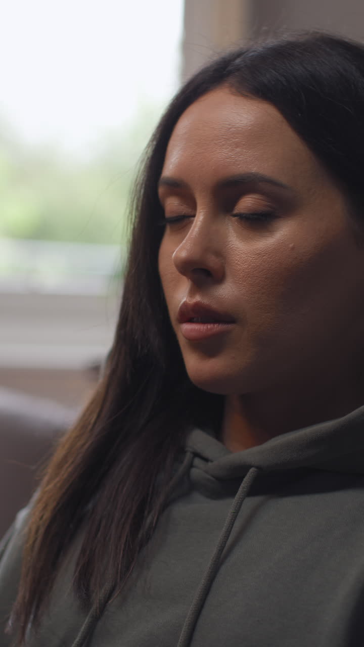 Vertical Video Of Anxious Woman Sitting Indoors On Chair Working From Home Using Laptop Worried About Cost Of Living Crisis