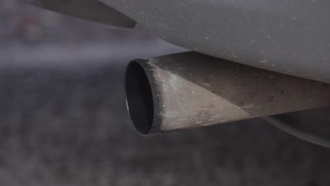 harmful polluting exhaust pipe fumes rising from stationary vehicle tailpipe