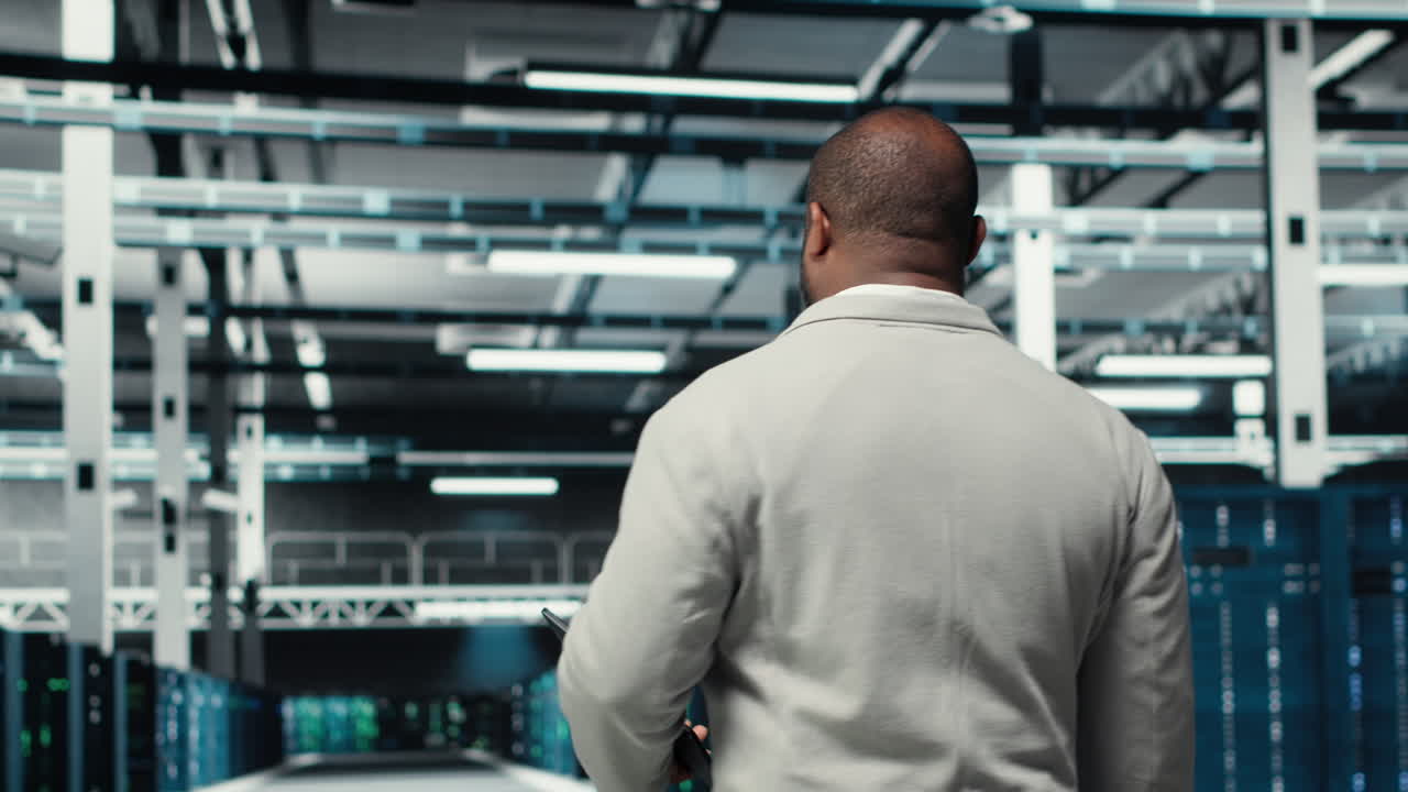 Admin walking in high tech data center facility with rows of supercomputers