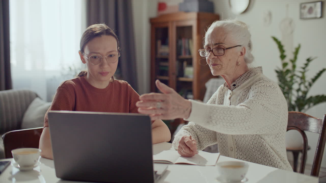 Donna anziana che impara a usare il laptop con l'aiuto della nipote