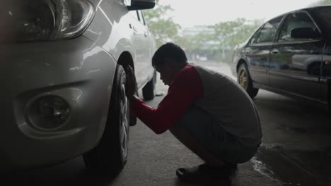 man cleaning a car tire