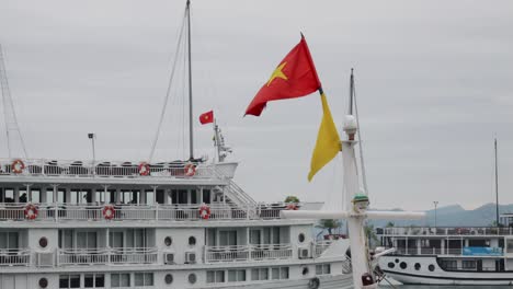 Vietnamesische-Und-Gelbe-Flagge-Im-Boot-Mit-Kreuzfahrtschiff-Im-Hintergrund