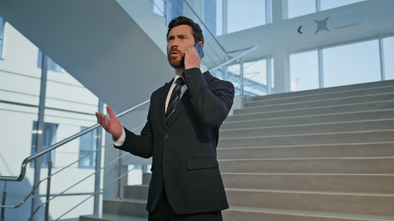 Boss worried cellphone call inside office building closeup. Frustrated man ceo