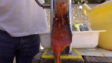 salsa de tomate recién prensada saliendo de la máquina