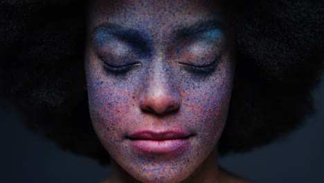 close up portrait beautiful african american woman wearing exotic face paint body art mysterious female with colorful makeup light flashing in dark background creative expression concept